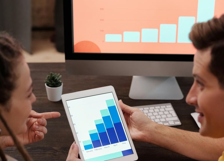 Man and Woman Looking at Bar Graphs On Screens
