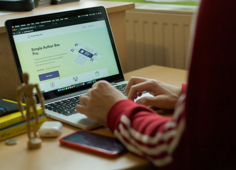 Person typing on laptop, web design page open