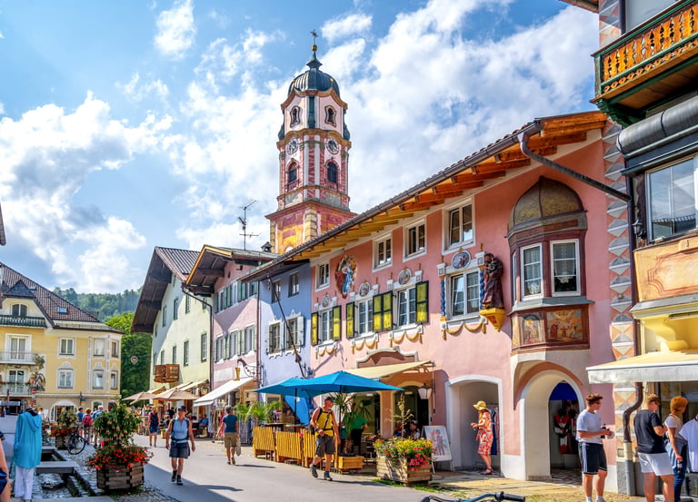 Colorful alpine houses and St. Peter and Paul church tower in Mittenwald, Bavaria, Germany.