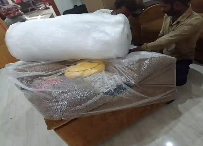 Seemanchal Packers & Movers staff carefully packing a sofa with bubble wrap and protective materials