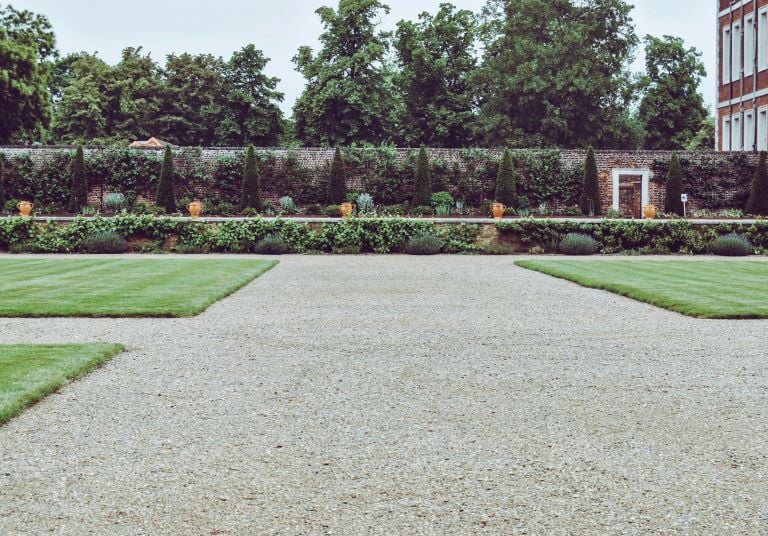 einen Garten mit einem Kiesweg und einem Schotterweg