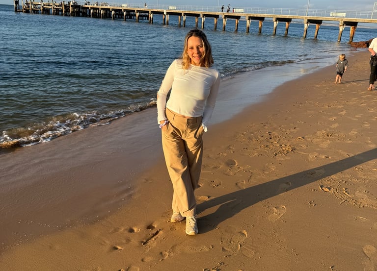 Una mujer caminando al lado de una playa 