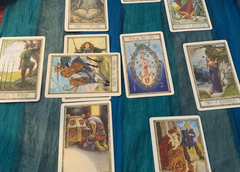 Mythic Tarot cards spread on blue fabric for a spiritual divination reading.