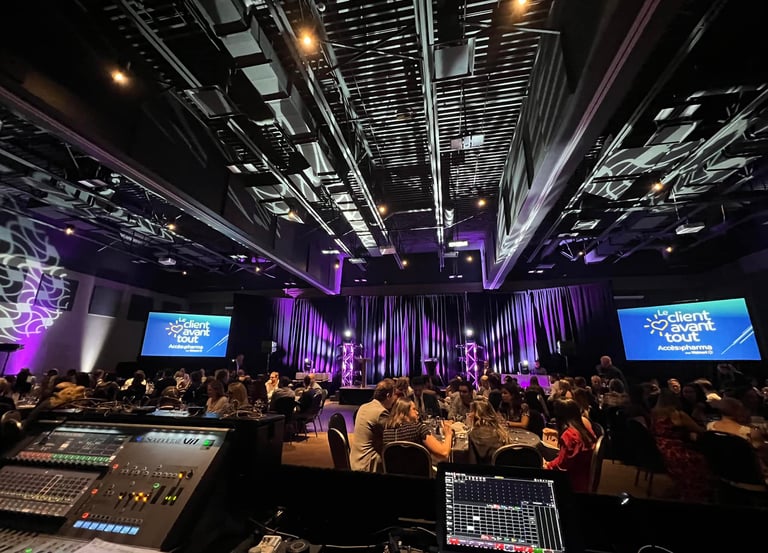 Corporate event gala with audience seating, stage lighting, and professional audio visual equipment.