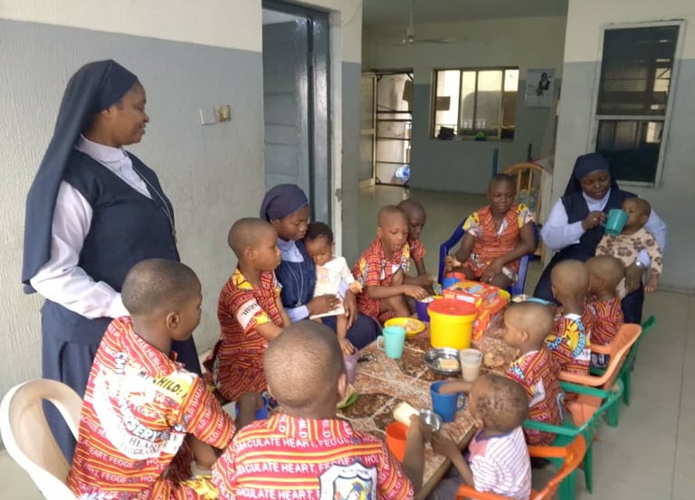 Our Sisters feeding some young children during snack time at the St. Joseph Orphanage.