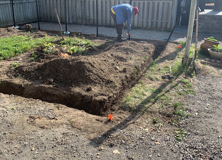 Manual excavation and soil preparation for a new garden bed or retaining wall footing.