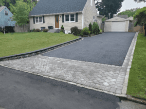 New asphalt driveway with interlocking stone paver apron and borders.