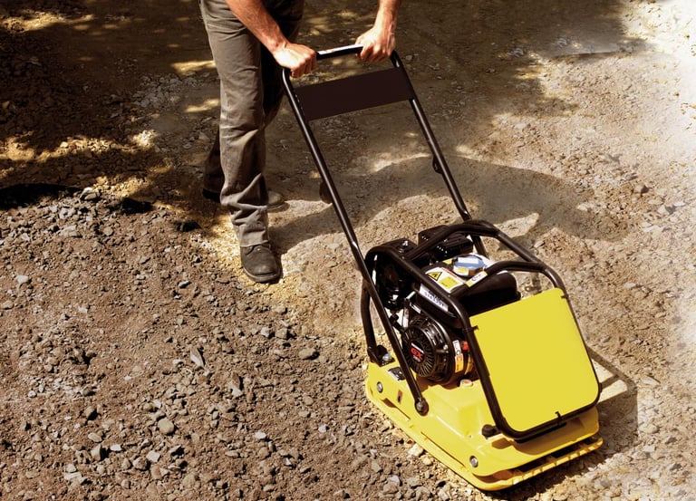 Gas-powered plate compactor ensuring a solid and level sub-base for patio installation.