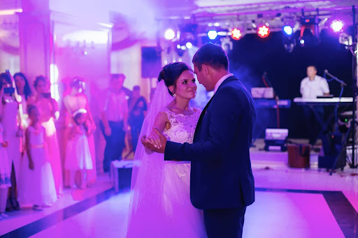 a bride and groom are standing in front of a band of people