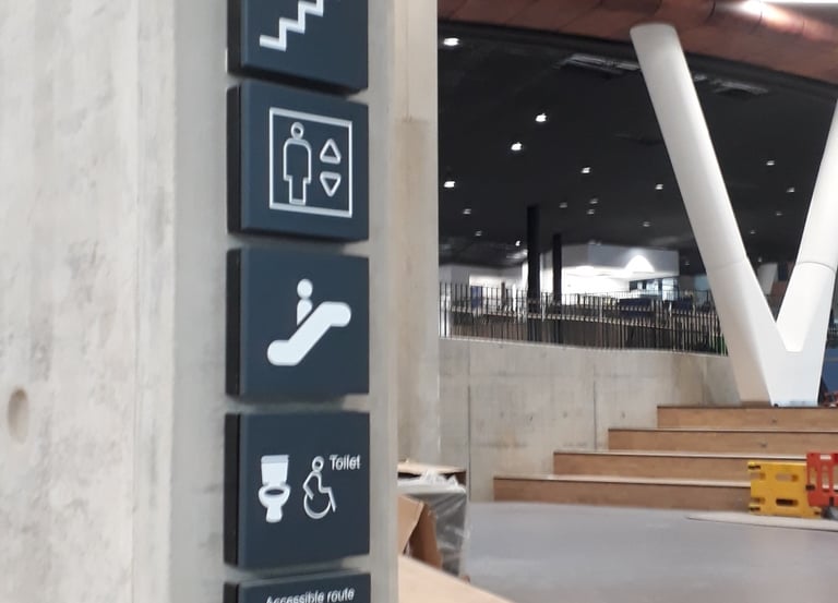 Installation of wall-mounted wayfinding signs including stairs, lift, escalator and accessible toile