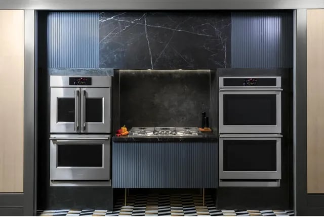 a kitchen with a marbled counter top and a black and white tile floor