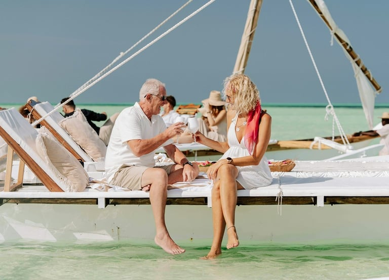 Un homme et une femme assis sur un voilier au bord de la plage avec de la famille et des amis