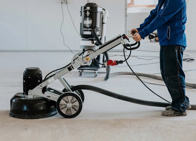 a man in a blue jacket is using a machine to clean the floor