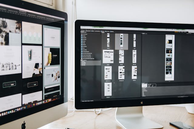 Two monitors displaying mockups for a website design