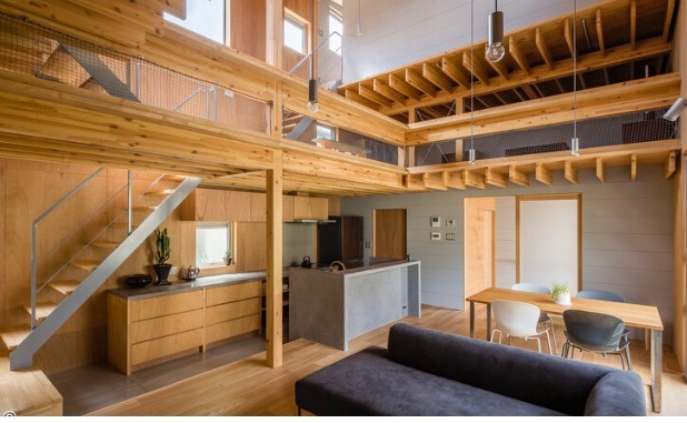 Modern open-concept Japanese house with natural wood framing, mezzanine loft, and industrial kitchen.