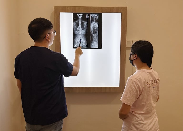 Chiropractor reviewing spine X-ray with patient at Sinisana Chiropractic.