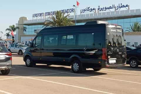 Black shuttle van parked at Essaouira Mogador Airport terminal for passenger transfer services.