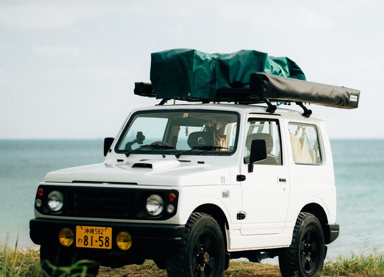 Suzuki Jimny with camping gear on the roof, parked by the ocean in Okinawa | Evertrail Okinawa