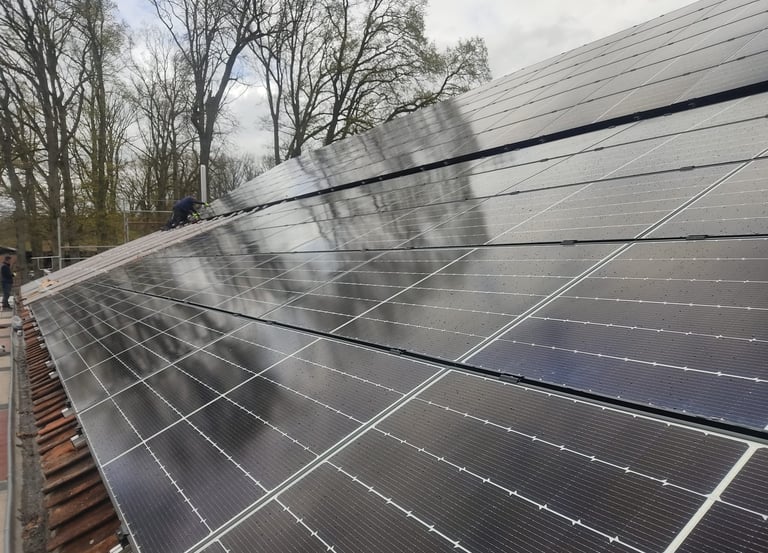 Ein Mann steht auf einem Dach mit Solarpaneelen.