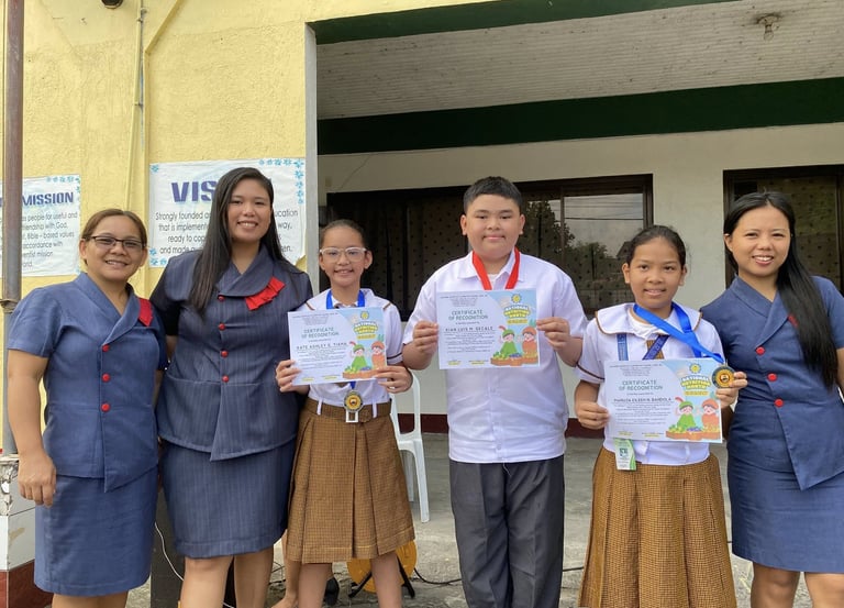 Groups of elementary students holding certifications with teachers