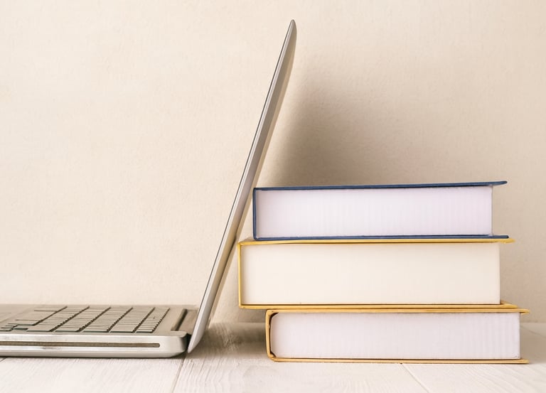 A laptop leaning against some books