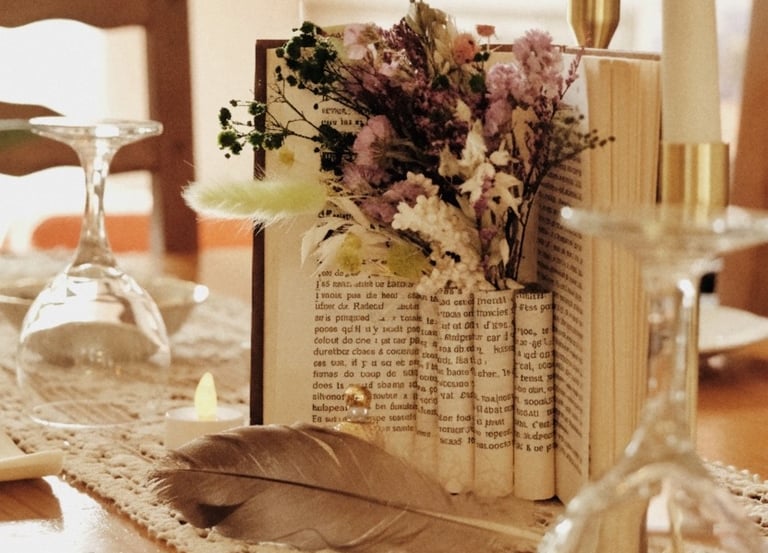 Centre de table avec livre, fleurs séchées et napperons