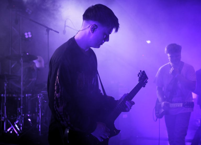 junger Musiker spielt bei Rock am alten Klärwerk auf einer Bühne.