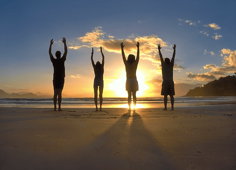 Moving the body through yoga on the beach during sunrise for personal wellness