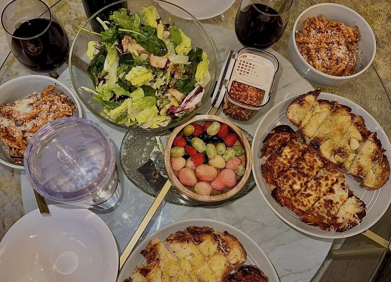 a table with plates of food and a bottle of wine