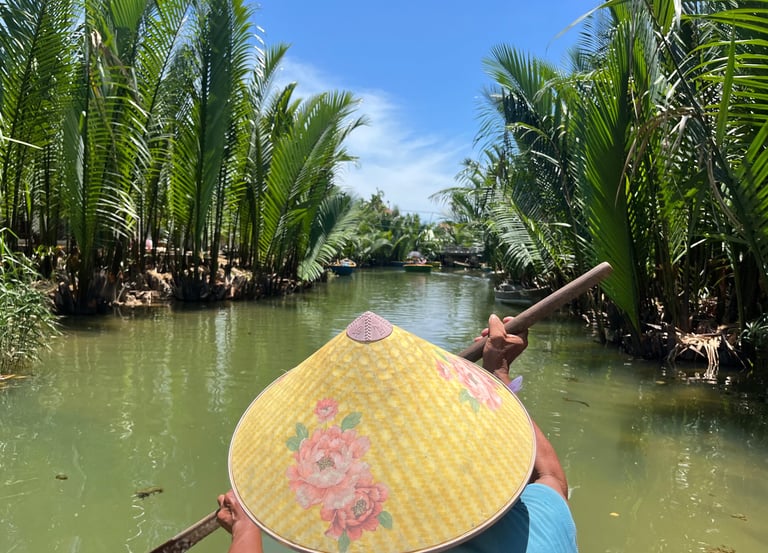 Homme vietnamien avec chapeau pointu sur un petit bateau