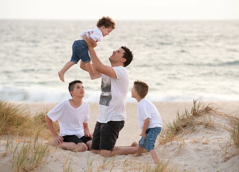 Father plays with sons at City Beach photo by Fisher Photography