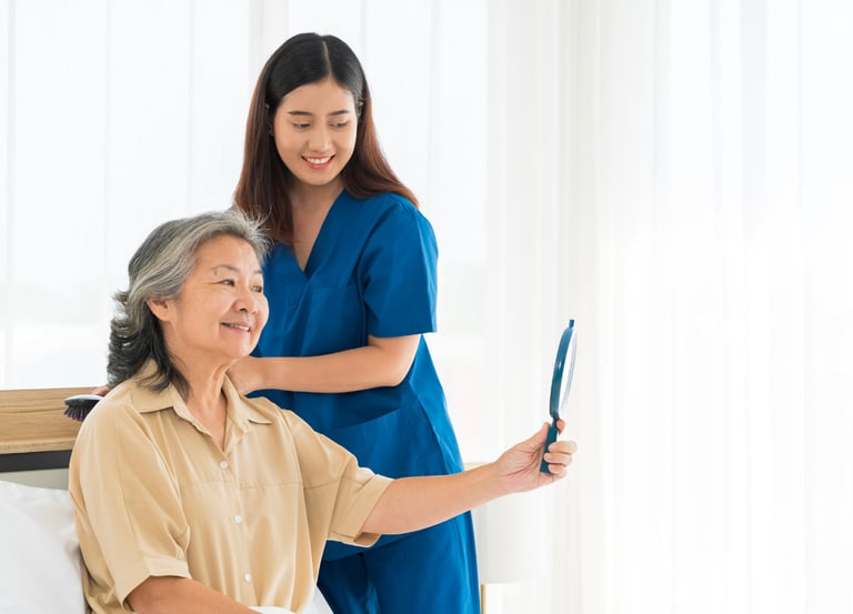 Female caregiver helping a female patient with her hair