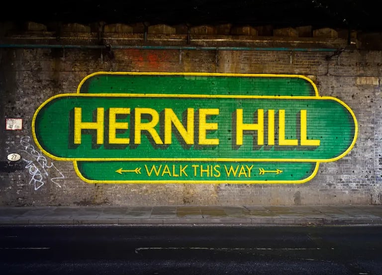 Herne Hill Walk This Way street art mural painted on a brick wall under a railway bridge.