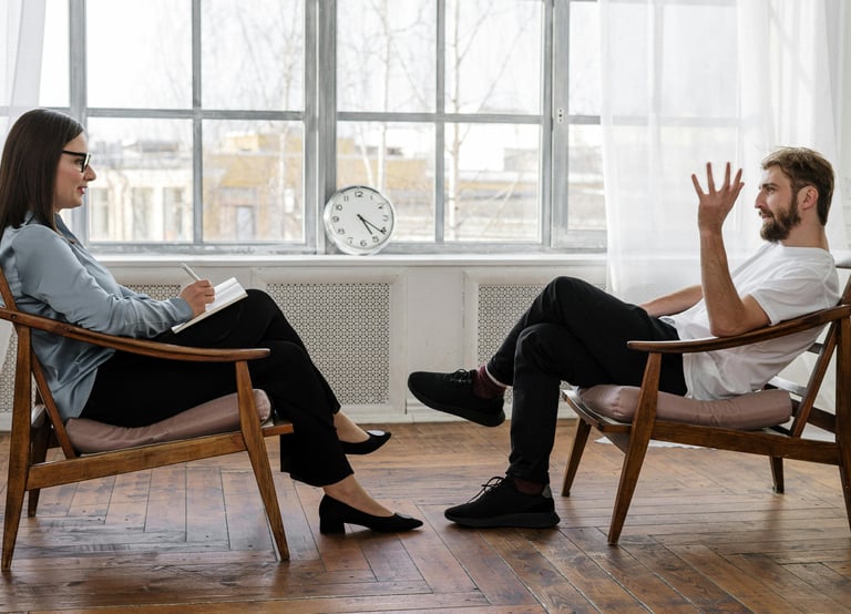 deux personnes parlent ensemble assises face à face lors d'une consultation thérapeutique 