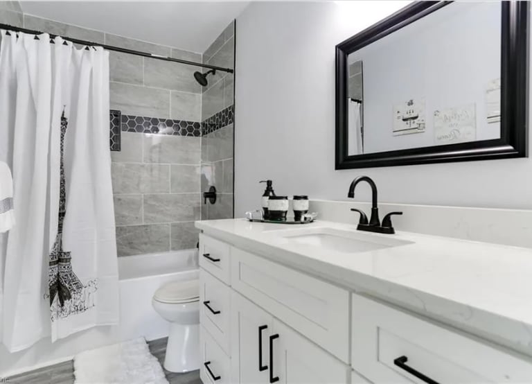 Gray tile walk-in shower with black showerhead in Newport news bathroom renovation