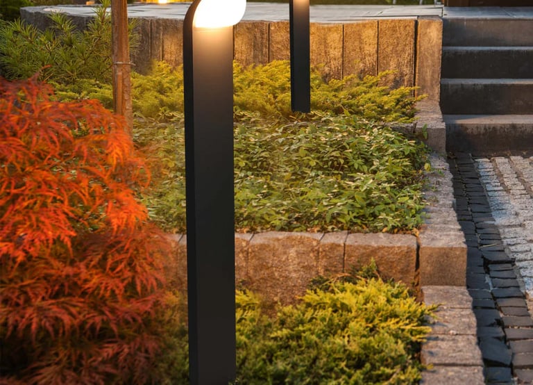 Modern LED path lights in a garden bed.