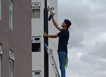 técnico realizando mantenimiento a cámaras de seguridad de un condominio