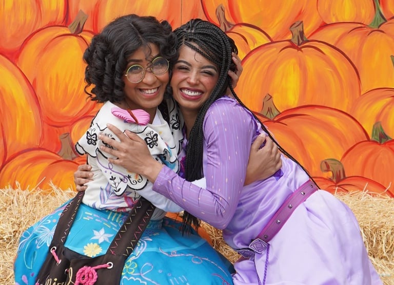 Mirabel and Asha hug for a photo at a fall festival