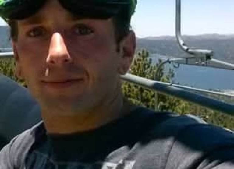 riding up a chairlift with goggles on head