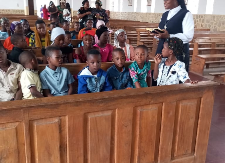 A Catholic nun teaching children sitting in wooden pews inside a church during a religious lesson.