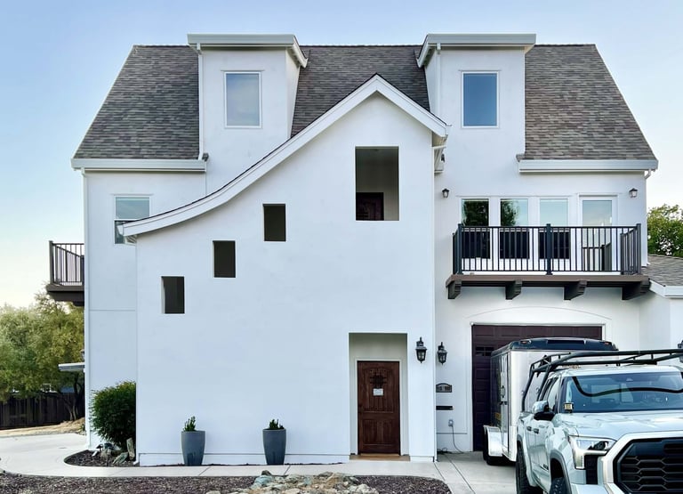 A French Revival architecture home with sloping roof lines, high dormers, and cantilevered decks.