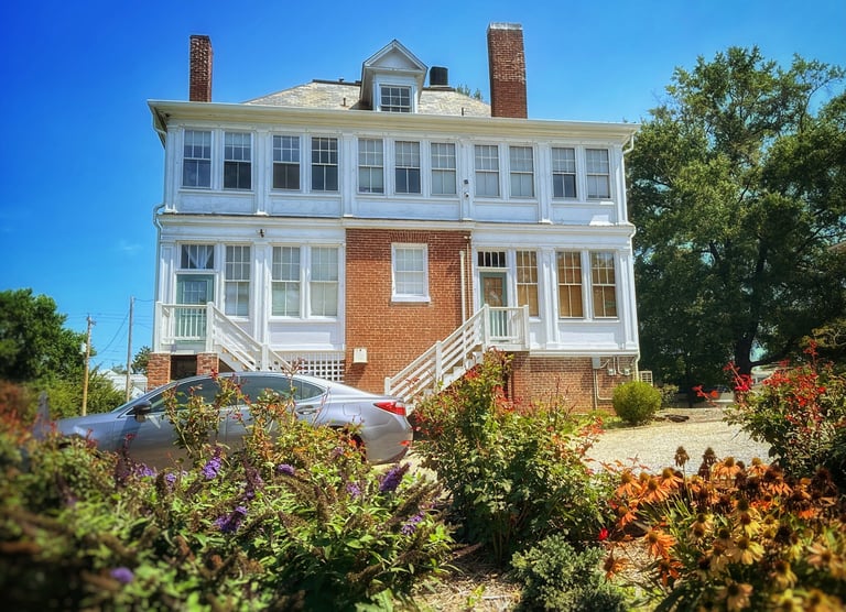 backyard of 2123 Rivermont apartments showing flowers in the foreground and house in background