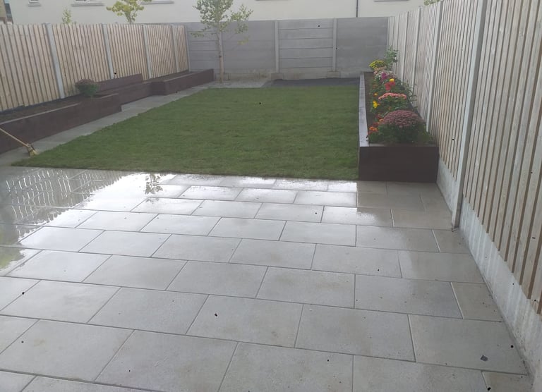 a backyard patio with a large lawn and a fenced in area