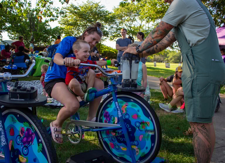 Parent and child mixing a smoothie on our blender bikes!