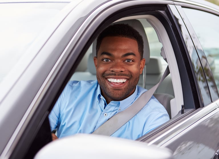 Motorista sorridente no carro APKTEM, transporte por aplicativo urbano.