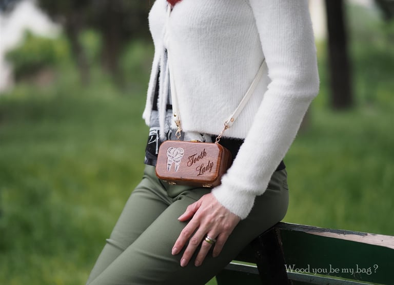 a woman with miniature wooden bag with tooth motif