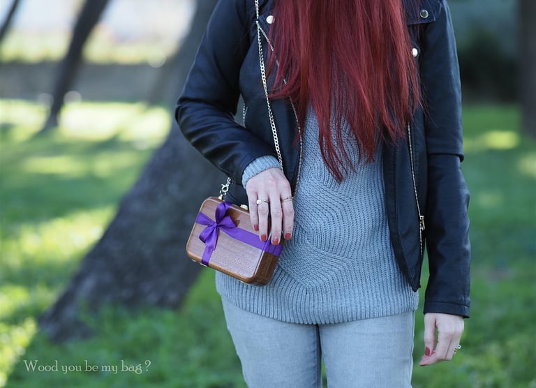 a woman with red hair and mahogany wood clutch decorated with purple satin bow