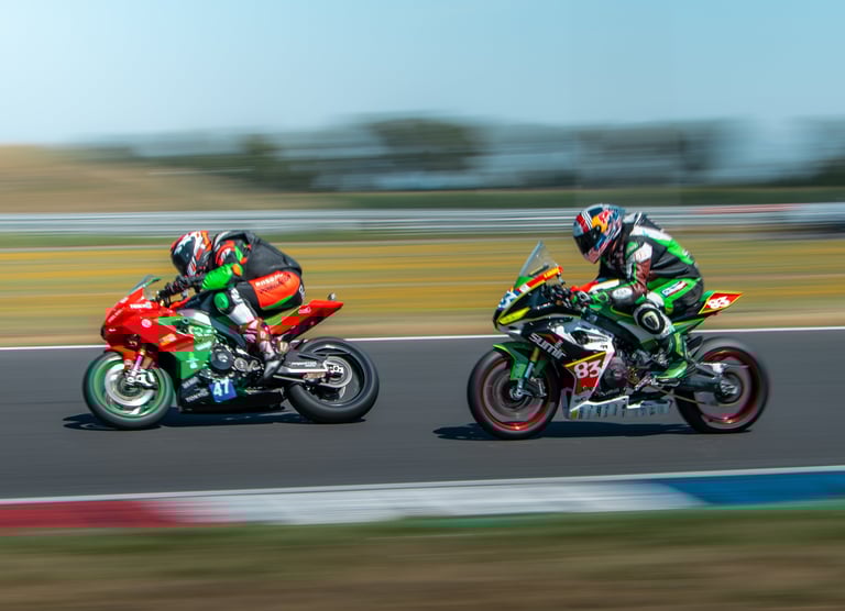 two people riding motorcycles on a track