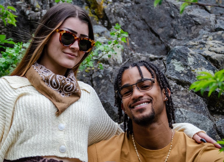Young Man and woman standing outside, smiling, and wearing fashion eyewear