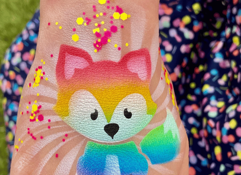Rainbow fox airbrush tattoo on a child’s hand. 